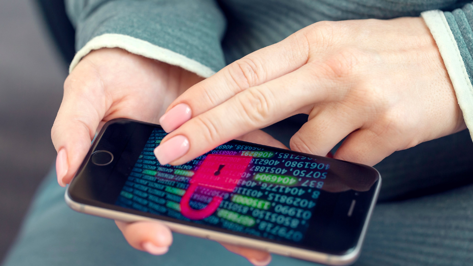 Des mains tiennent un cellulaire qui affiche un grand cadenas à l’écran.