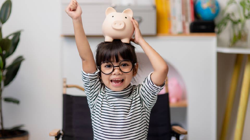 Petite fille qui économise de l'argent dans une tirelire