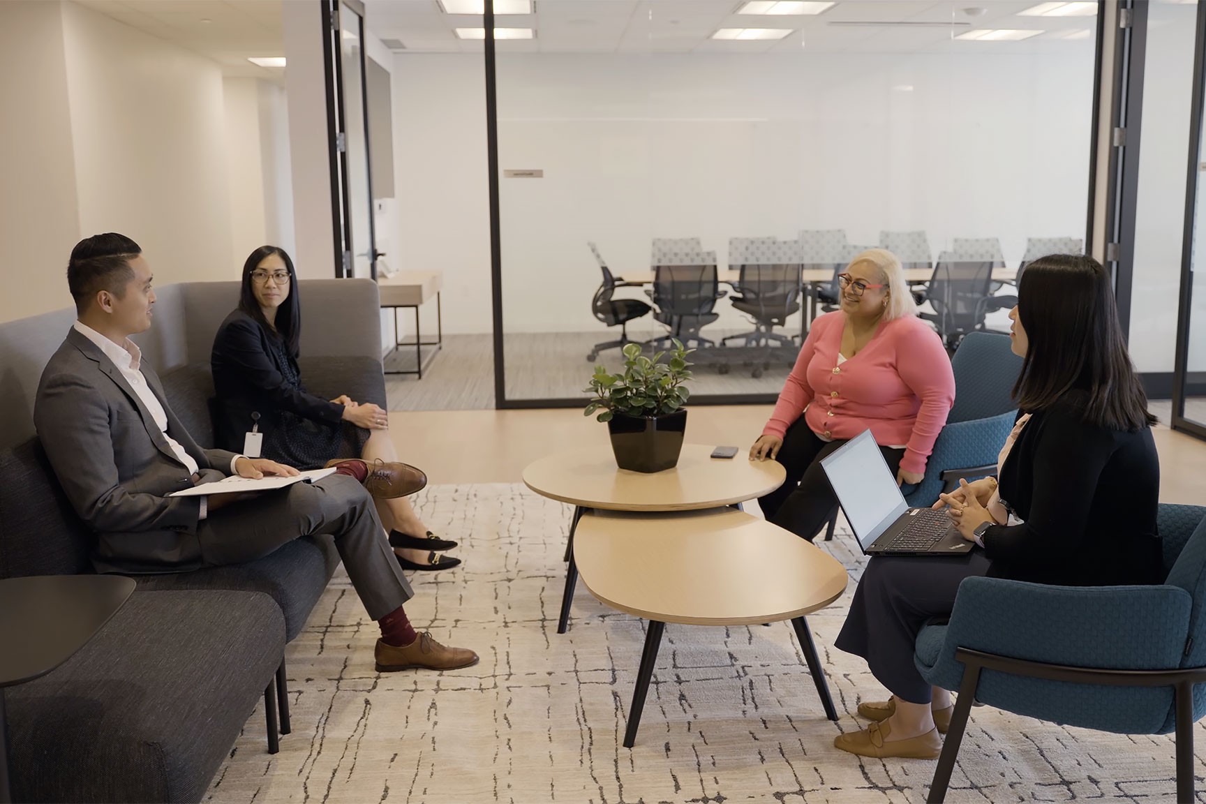 A group of employees sitting around each other in an office
