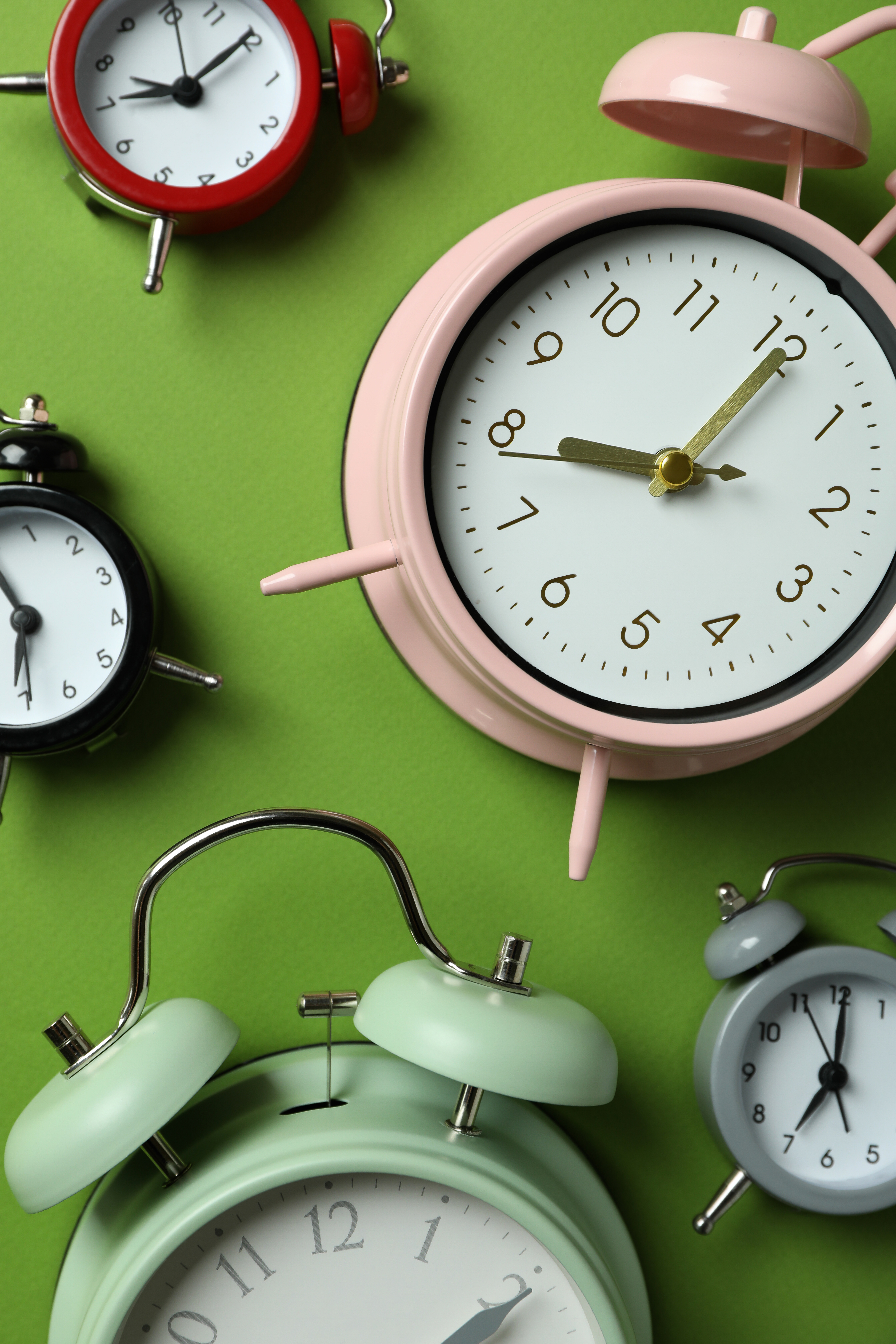 collection d’horloges réveils colorées sur fond vert